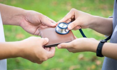 Hands checking wallet with stethoscope | Fewer Americans Feel They’re Financially Healthy in 2022 | featured