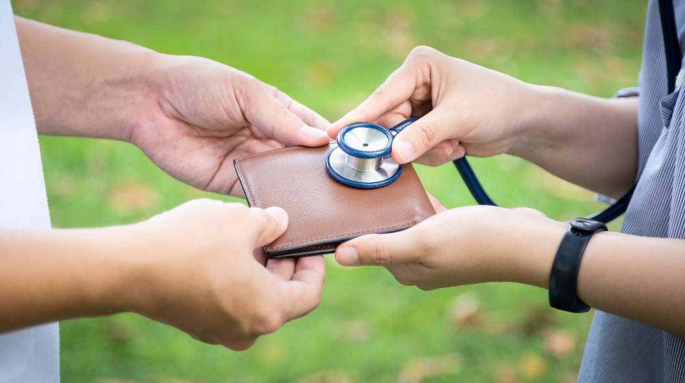 Hands checking wallet with stethoscope | Fewer Americans Feel They’re Financially Healthy in 2022 | featured