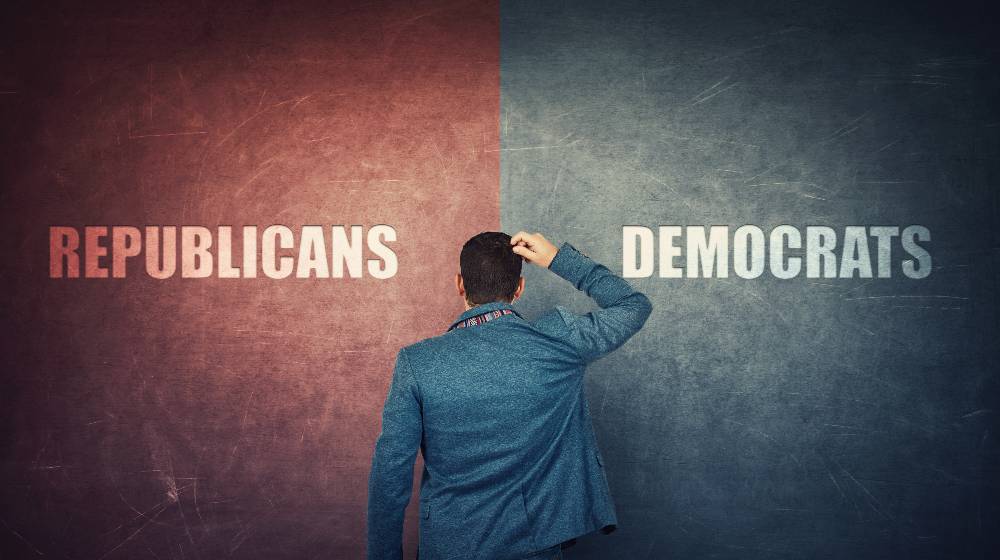 Puzzled businessman and a split wall with Democrats versus Republicans, red vs blue sides | New Gallup Poll Shows Massive Voter Shift of Voters From Democratic to Republican | featured