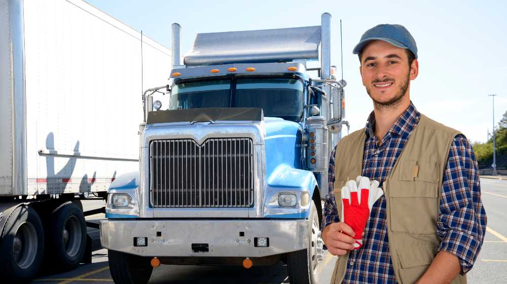 Young truck driver with his truck | 18-Year Olds Now Allowed to Drive Semi Trucks To Help Ease Supply Chain Crisis | featured