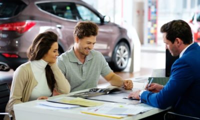 Beautiful-young-couple-reading-a-booklet-at-the-dealership-showroom-Car-Dealers-SS-Featured.jpg