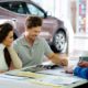 Beautiful-young-couple-reading-a-booklet-at-the-dealership-showroom-Car-Dealers-SS-Featured.jpg