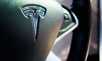 Tesla logo on black leather luxury electro mobile car steering wheel | Tesla Recalls 817,000 EVs Over Seat Belt Safety Issues