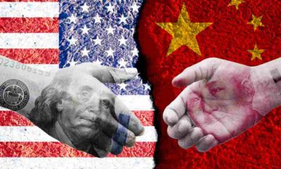Poll - US dollar and China Yuan banknote print screen on handshake with both flags countries | China Didn’t Buy $200 Billion Worth of US Goods It Said It Will | featured