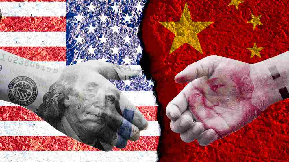 Poll - US dollar and China Yuan banknote print screen on handshake with both flags countries | China Didn’t Buy $200 Billion Worth of US Goods It Said It Will | featured