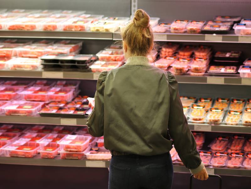 Woman purchasing a packet of meat at the supermarket | Soaring Meat Prices Led To Tyson Foods’ Profits