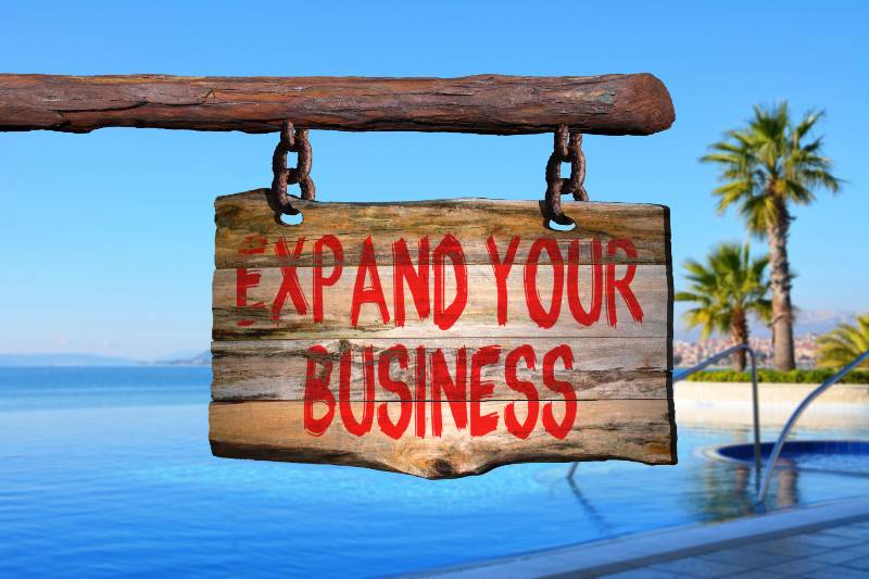 expand your business motivational phrase sign on old wood | Top Positions You Need to Fill to Expand Your Business