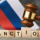 judge's gavel, wooden cubes with the text on the background of the Russian flag | Will Economic Sanctions Work Against Russia This Time? | featured
