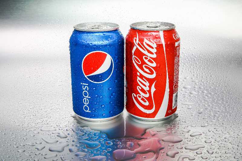 Coca-Cola and Pepsi cans on metal background | Coke, Pepsi, Starbucks, and McDonald’s Join Russian Boycott