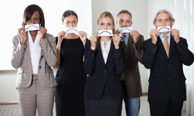 Diverse group of business people holding a card with sad sign by their faces | 20% of Workers Who Switched Jobs Now Regret Their Decision | featured