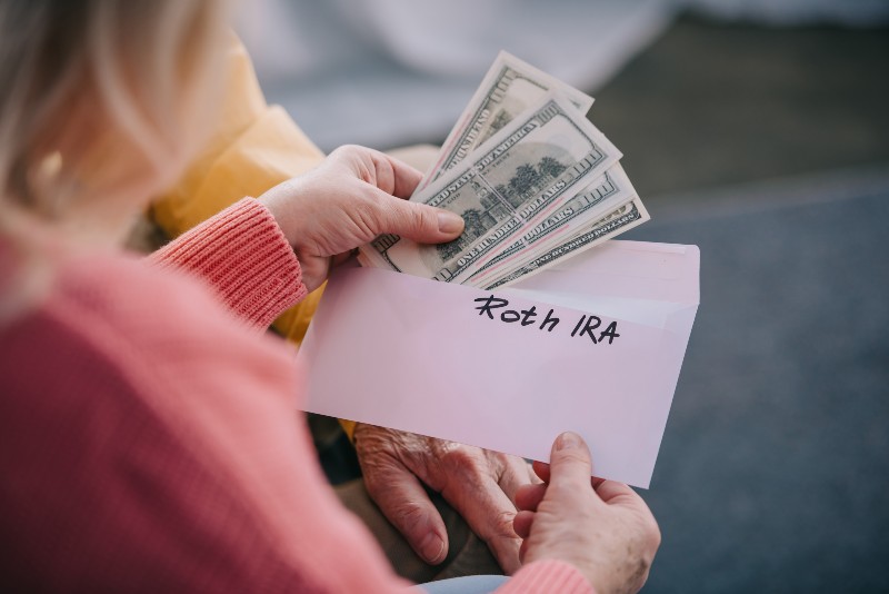 cropped view of senior couple holding envelope with 'roth ira | 13 COSTLY ROTH IRA Mistakes to AVOID