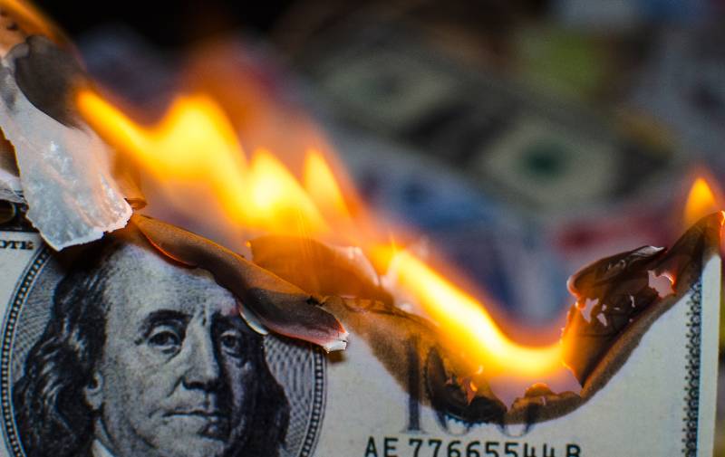 A hundred dollar bill in American US currency is on fire | 8.5% March Inflation Rate Highest Since Reagan Administration