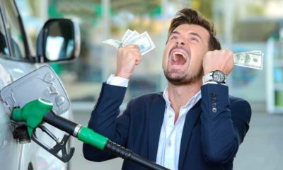 Emotional businessman counting money with gasoline refueling car at fuel station | Americans Blame Democrats For Expensive Gas Prices | featured