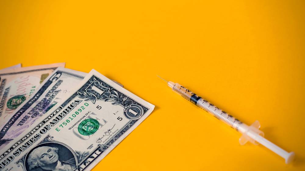 Insulin syringe and dollars money banknotes | House Bill OKs Bill Reducing Copay Insulin Costs to $35 | featured