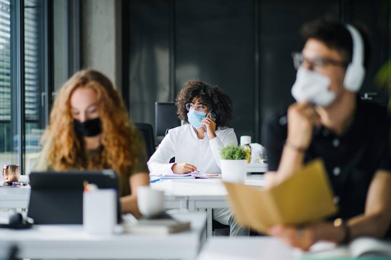 Young people with face masks back at work or school in office after lockdown | It’s Back To The Office For the Majority of Workers