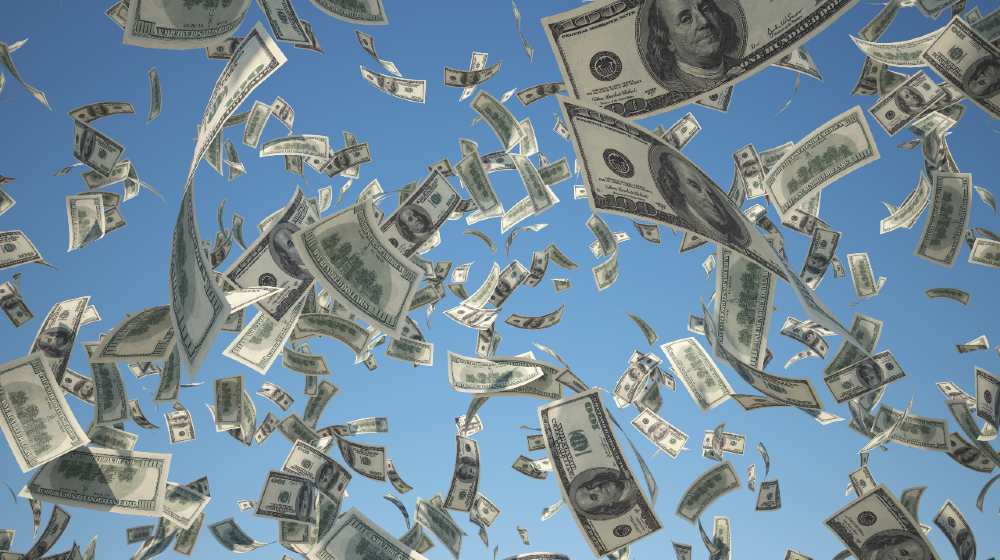 100 US Dollar, bills flying on blue sky background-ss-featured