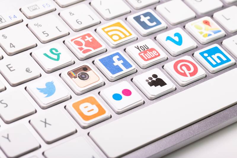 A social media logotype collection printed and placed on modern computer keyboard-Marketing and Social Media