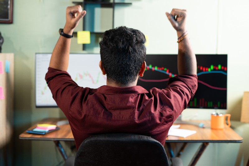 Back view of successful Trader celebrating for profit on shares by looking charts | Time To Exit