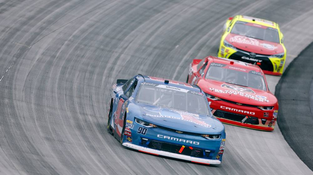 Brandon Brown (90) races through the field at the Bar Harbor 200 | Officials Rescind LGBcoin.io’s NASCAR Sponsorship For Brandon Brown | featured