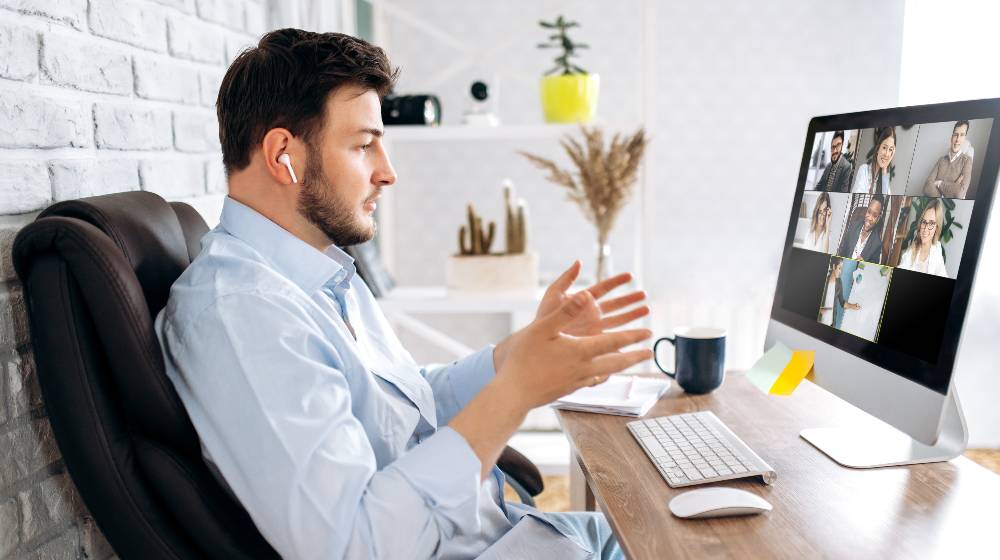 Business partners communicate via video using laptop | CEO Fires 900 Workers Via Zoom Call, Accuses Them of Stealing | featured