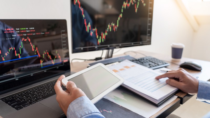 Businessman broker Analyzing finance data graphs and reports on screen for investment purposes | Stock Market Investor
