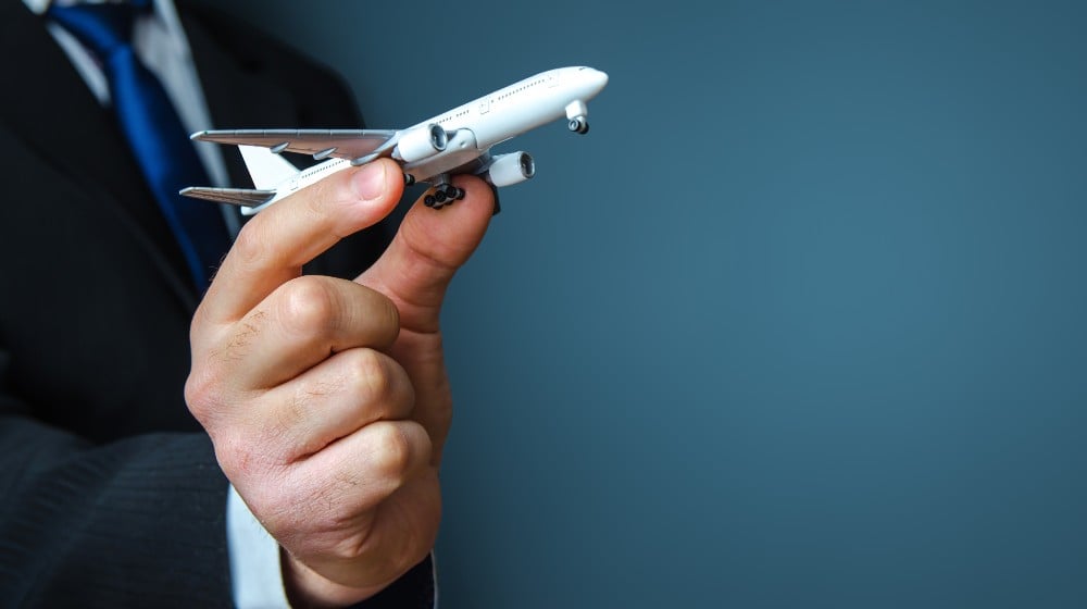 Businessman holding a airplane | Putin Helps Russian Airlines By Seizing Leased Planes | featured