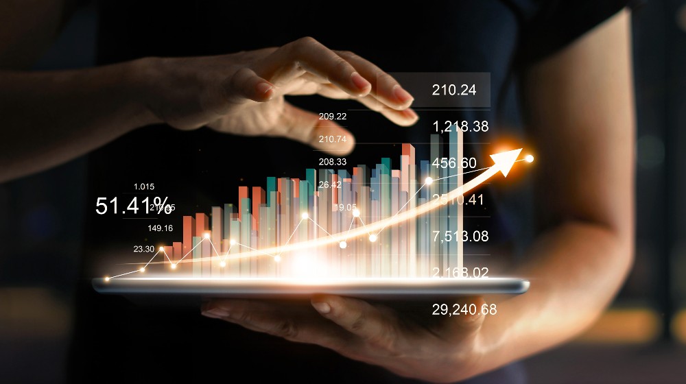 Businessman holding tablet and showing a growing virtual hologram of statistics, graph and chart with arrow up | Growing A Company Is Hard; Turning Around A Grown-Up Company Is Harder | Featured