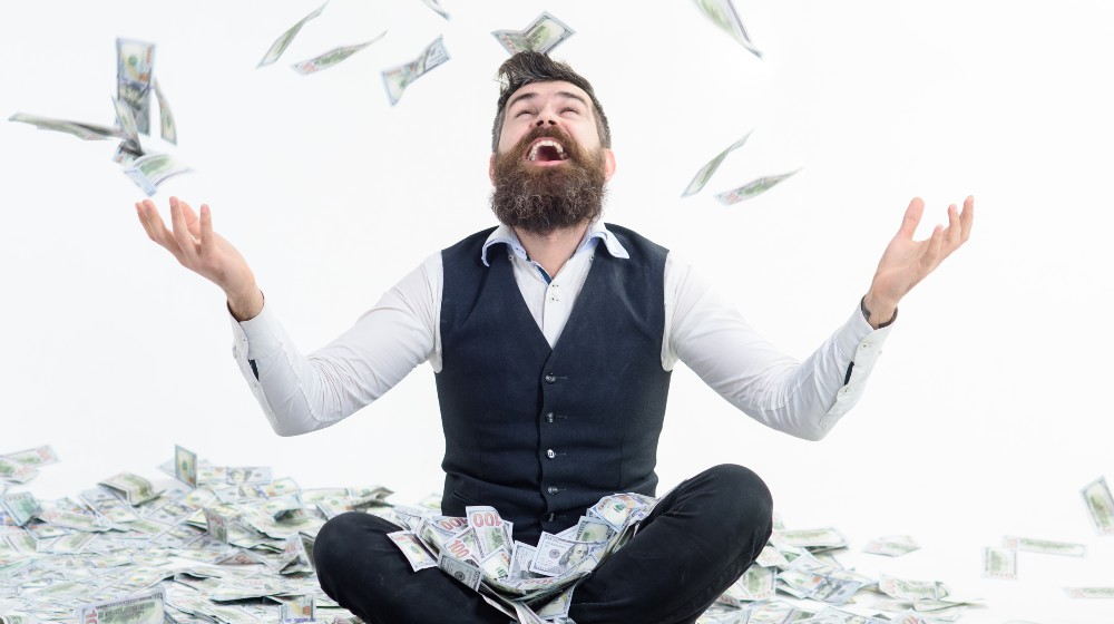 Businessman is happy with his money. Banknotes, cash dollars fly in air | Wealthiest 1% Americans Owe $163 Billion Yearly In Taxes | featured