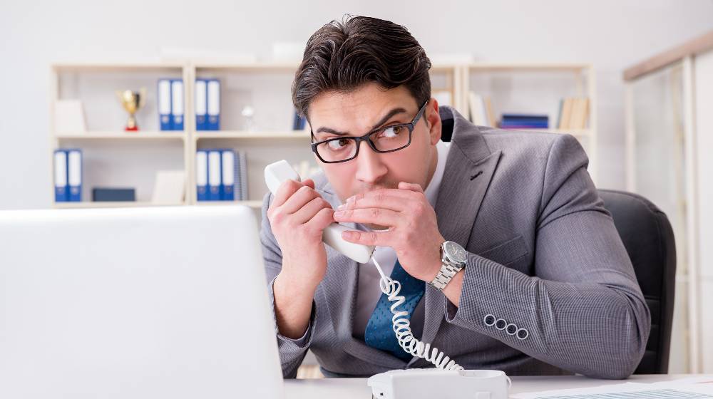 Businessman leaking confidential information over phone | 3 in 4 American Voters Want Lawmakers Banned From Trading Stocks | featured