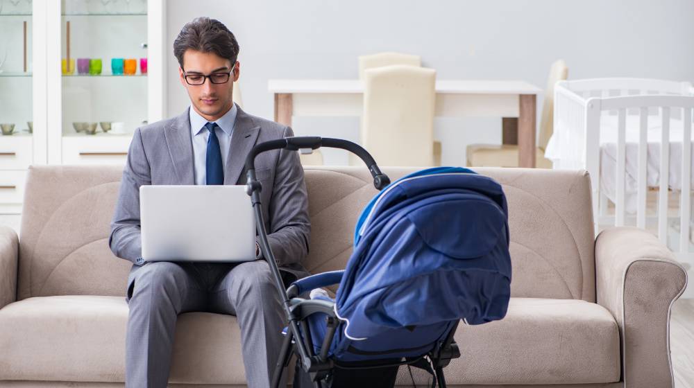 Businessman looking after newborn baby at home and teleworking | Palantir Exec Calls Men Who Take Long Paternity Leave ‘Losers’ | featured