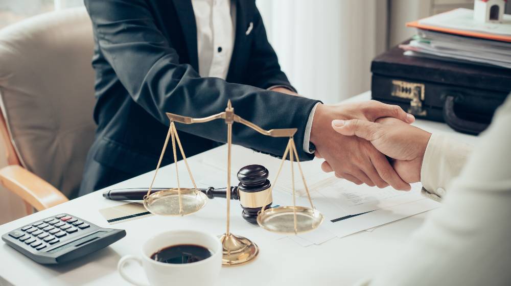 Businessman shaking hands to seal a deal with his partner lawyers | Corporate Finance Law - Planning Your Exit As a Private Investor | featured