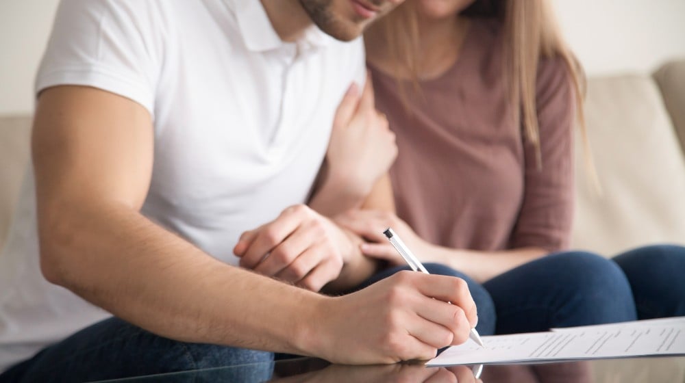 Close up of couple signing documents | American Home Buyers Rushing To Close Deals Before Mortgage Rates Go Higher | featured