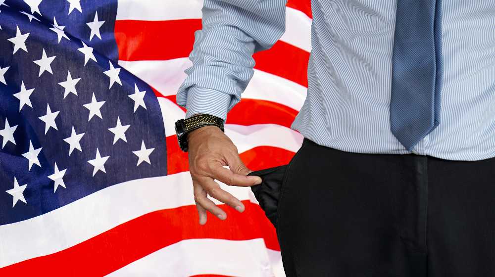 Close-up of hand of man in suit turning pocket of his trousers inside out and showing it empty | Inflation Wipes Out Wage Increases For Many Americans | featured