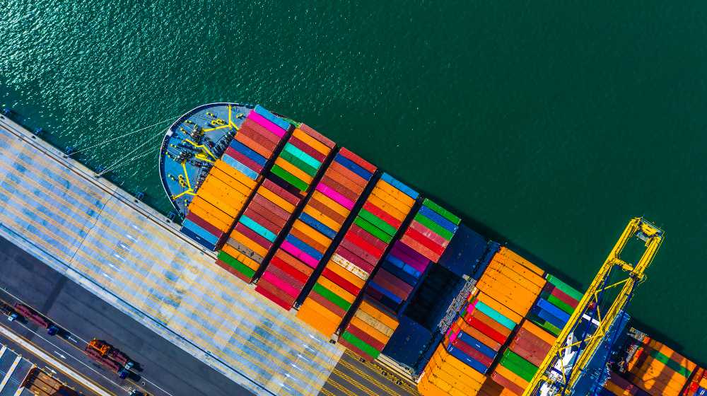 Container cargo freight ship with working crane bridge discharge | China Port Shutdown Will Lead To More Shortages | featured