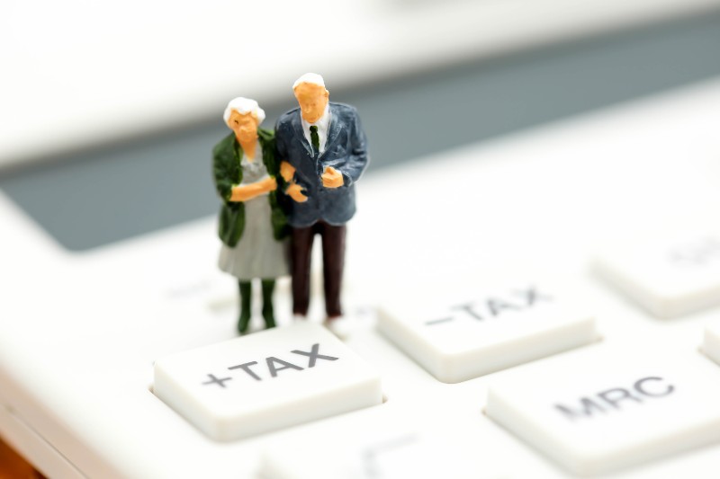 Couple oldman standing with Calculator,business,tax concept-Taxes in Retirement
