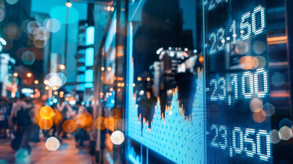 Display of Stock market quotes with city scene reflect on glass-Ban Lawmakers From Trading Stocks-ss-featured