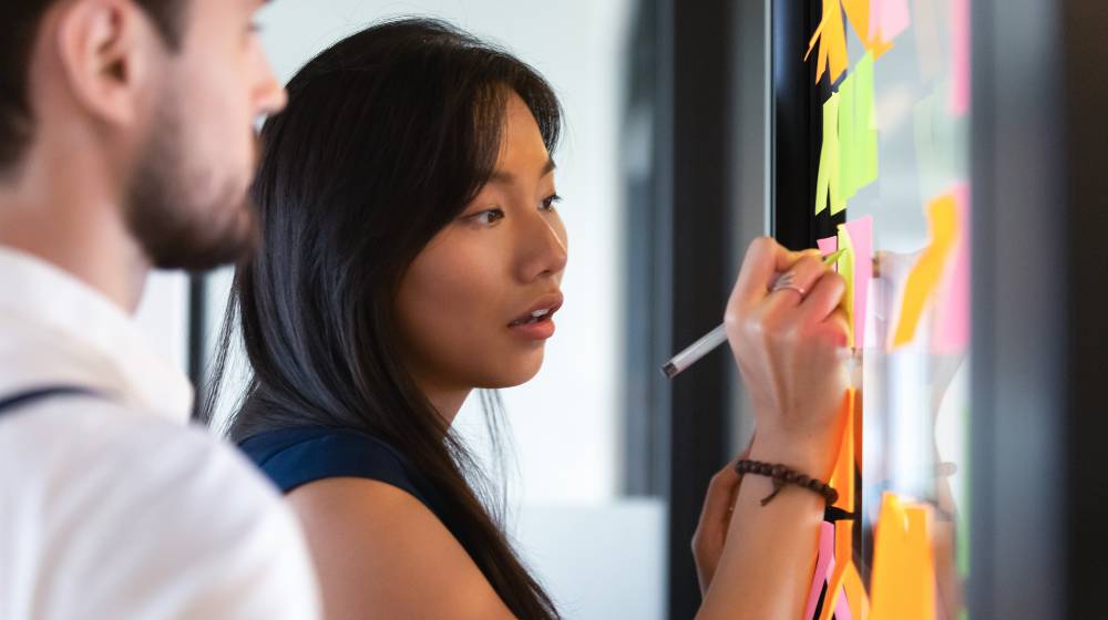 Focused asian business woman mentor coach leader writing idea | How Leaders Should Determine Their METHODS? | featured
