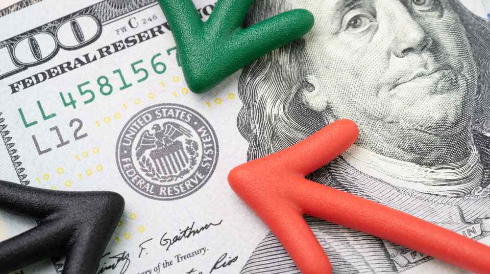 Green, red and black arrow pointing to US Federal Reserve | The Fed Will Start Tapering Its Bond Purchases This Month | featured