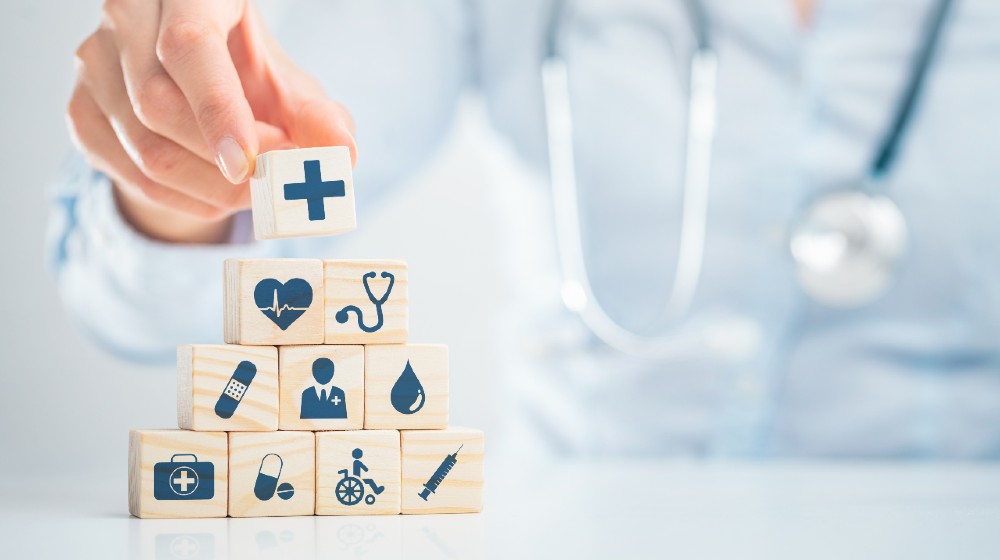 Hand arranging wood block with healthcare medical icon-Patient Square Capital-ss-featured