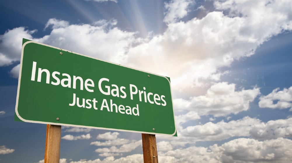 Insane Gas Prices Green Road Sign with Dramatic Clouds, Sun Rays and Sky | Gas Prices Are Now Highest Since 2014 | Featured