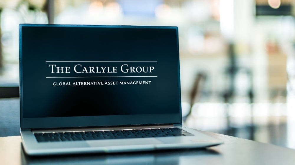 Laptop computer displaying logo of The Carlyle Group, an American multinational private equity, alternative asset management and financial services corporation | BCIM Corp Sells 869 Shares of The Carlyle Group Inc | Featured