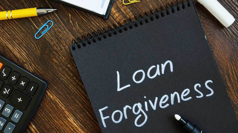 Loan forgiveness note on notepad black page | Troubled student loan forgiveness program gets an overhaul | featured
