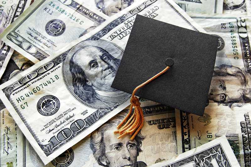 Miniature graduation cap on hundred dollar bills-Student Loan Forgiveness Program