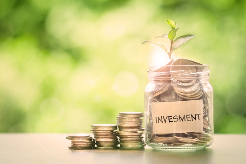 Plant growing in Coins glass jar with investment paper label for money saving and investment financial concept-purpose of money-ss