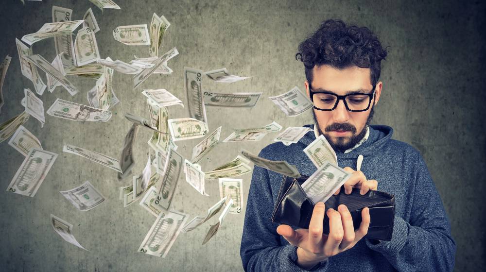 IMF-Sad man looking at his wallet with money dollar banknotes flying out away | Biden’s $3.5T Spending Program Will Only Make Things Worse | featured