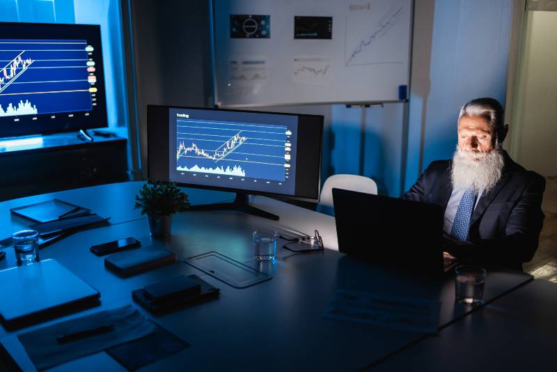 Senior business man working at night inside fintech company office | Corporate Insiders