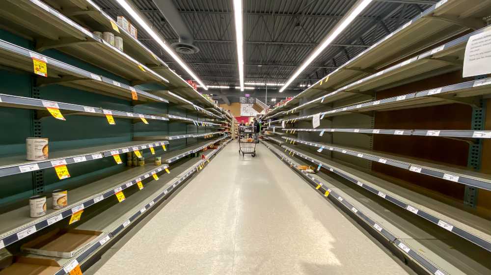 Shelf at a supermarket mostly empty with only a few packages of toilet paper left | Americans may face empty shelves | featured