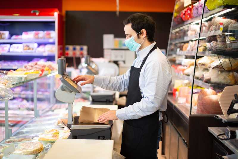 Shopkeeper running his business while wearing a mask-Pandemic Worker