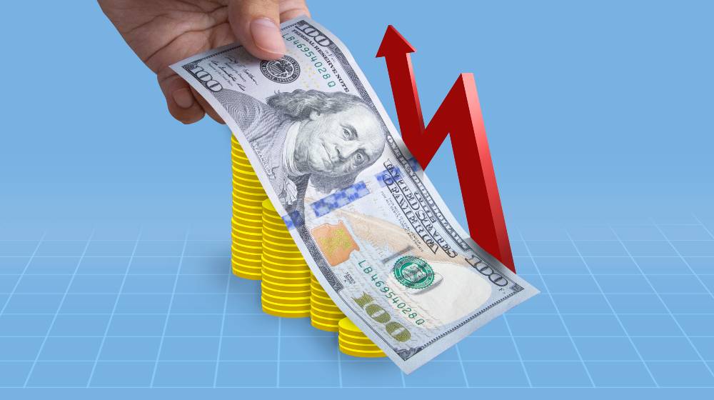 Successful money financial investment concept,100 Dollar bill lay on top of coins | Despite Pay Hikes, Americans Are Earning Less Due to Inflation | featured