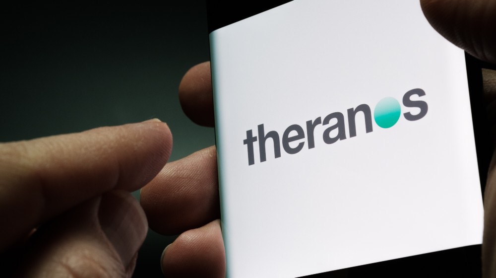 Theranos company logo seen on smartphone screen | Theranos Founder Elizabeth Holmes Found Guilty on 4 Counts of Fraud | featured